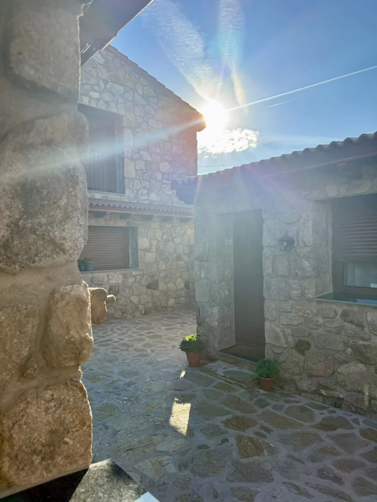 Entrada de piedra de Monte Bebiome al sol, en Peguerinos, Sierra de Guadarrama